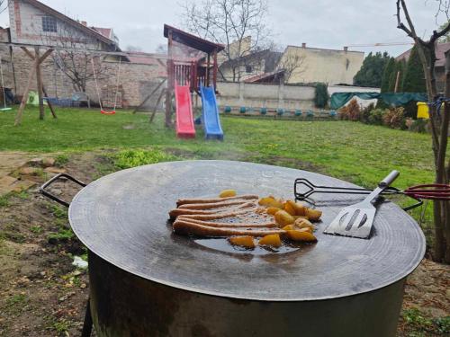 a grill with a bunch of hot dogs and a fork at Skylark Relax Apartman in Szeged