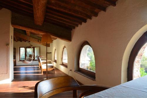 a room with arched windows and a table and chairs at Collerosso Appartamenti per vacanze in Calci