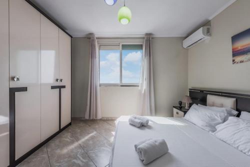 a bedroom with a large white bed and a window at Three Bedroom Romantic Promenade Apartment in Durrës