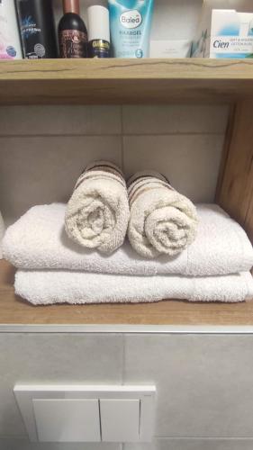 duas toalhas enroladas numa prateleira na casa de banho em Apartman Noel Sarajevo em Sarajevo