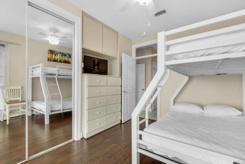 Un dormitorio con dos literas y un espejo. en Destiny Beach Villas #11B- Beach Oasis, en Destin