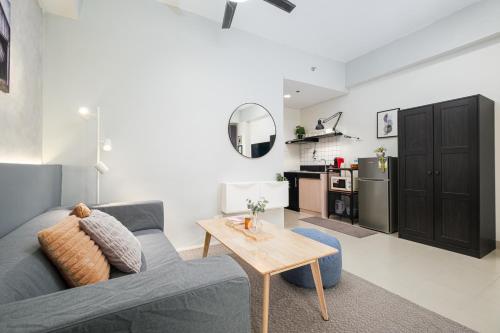 a living room with a blue couch and a table at Resort-style Condo in Quezon City with Free Parking, Netflix and Smartlock in Manila