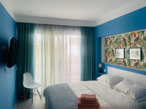 a bedroom with blue walls and a bed and a window at Petrus Studio with balcony in Thessaloniki