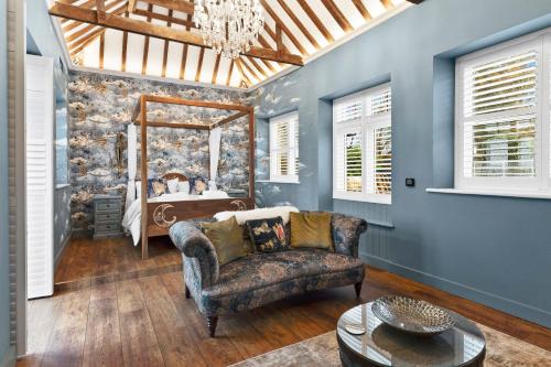 a living room with a couch and a mirror at Normanton Park House - Luxury Rutland Water Home in Oakham