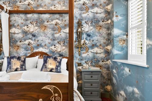 Schlafzimmer mit einem Bett mit blauer Wand in der Unterkunft Normanton Park House - Luxury Rutland Water Home in Oakham