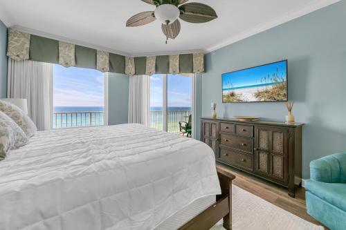 a bedroom with a large bed and a tv at Grandview East 702 in Panama City Beach
