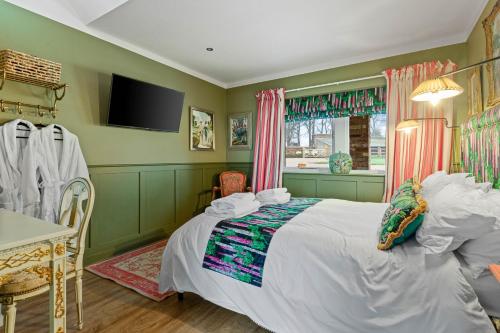 a bedroom with a bed and a tv in it at Normanton Park House - Luxury Rutland Water Home in Oakham