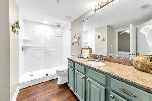 a bathroom with a sink and a toilet and a mirror at Grandview East 702 in Panama City Beach