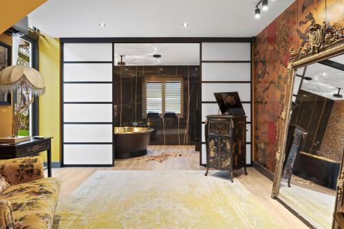 a bathroom with a large sliding door with a tub at Normanton Park House - Luxury Rutland Water Home in Oakham