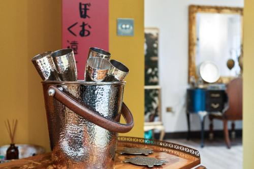 a metal bucket filled with drinking glasses on a table at Normanton Park House - Luxury Rutland Water Home in Oakham
