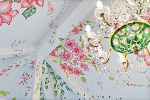 a room with floral wallpaper and a chandelier at Normanton Park House - Luxury Rutland Water Home in Oakham