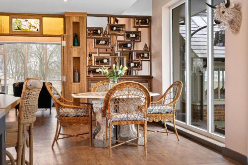 a dining room with a table and chairs at Normanton Park House - Luxury Rutland Water Home in Oakham