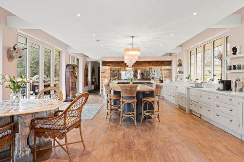 a large kitchen with a table and chairs at Normanton Park House - Luxury Rutland Water Home in Oakham