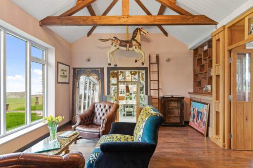 a living room with couches and a horse on the wall at Normanton Park House - Luxury Rutland Water Home in Oakham