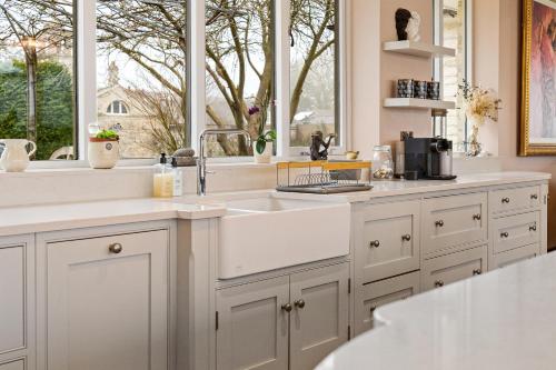a kitchen with a sink and a window at Normanton Park House - Luxury Rutland Water Home in Oakham