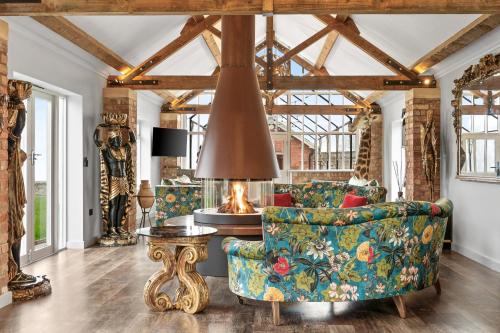a living room with a couch and a fireplace at Normanton Park House - Luxury Rutland Water Home in Oakham
