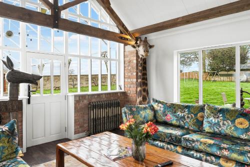 a living room with a couch and a table at Normanton Park House - Luxury Rutland Water Home in Oakham
