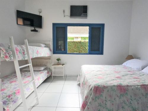1 Schlafzimmer mit 2 Etagenbetten und einem Fenster in der Unterkunft Casa com piscina a 250m da praia! in Ubatuba