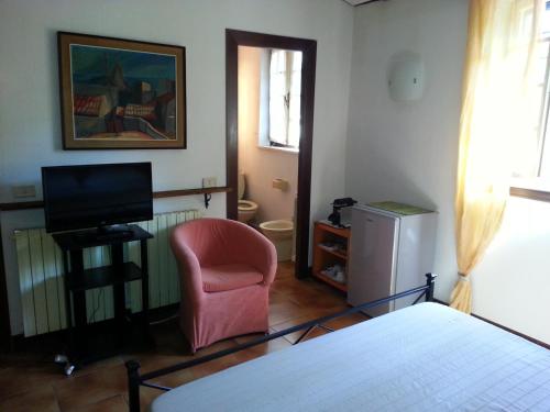 a bedroom with a bed and a chair and a television at Villa di Christian e Michelle in Rome