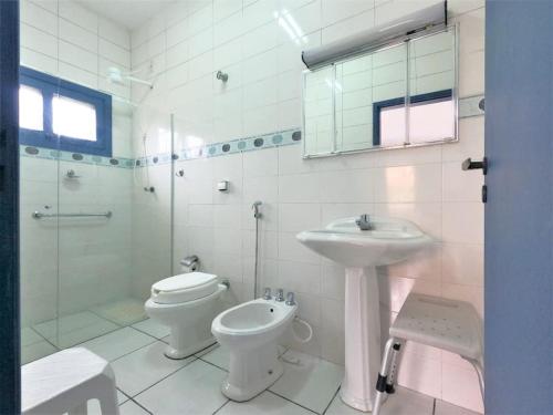 ein Bad mit einem Waschbecken, einem WC und einer Dusche in der Unterkunft Casa com piscina a 250m da praia! in Ubatuba