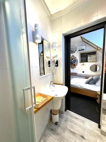 a bathroom with a sink and a mirror and a bed at Pensjonat Melaxa in Węgierska Górka
