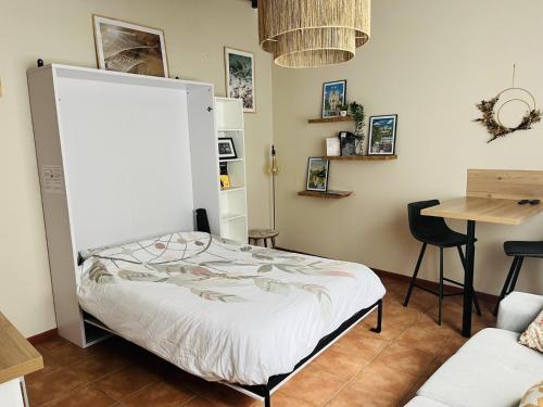 a bedroom with a bed and a table and a chair at Logement, plein centre du village de Verzy in Verzy