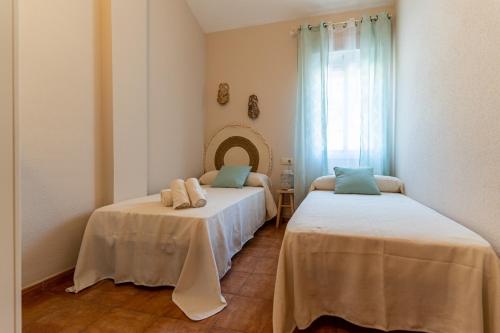 two beds in a room with a mirror at Casa El Lago Alojamiento Rural in Las Jaras