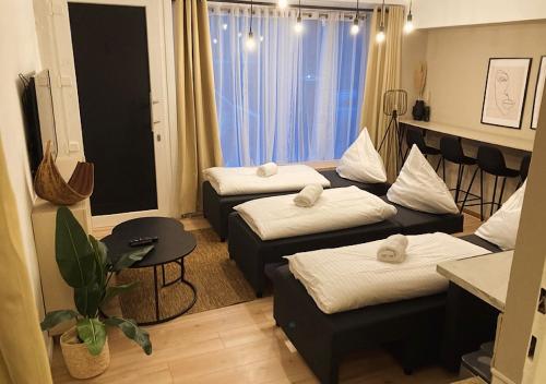 a small room with three beds and a window at City-Apartment Kreuzviertel-Lädchen mit gratis Parkplatz in Münster