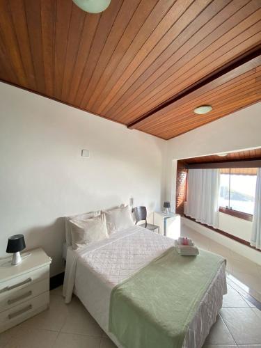 a bedroom with a bed and a wooden ceiling at Sentinelas do Mar in Arraial do Cabo