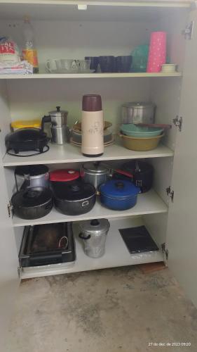 a kitchen shelf filled with pots and pans at ESPAÇO ShEHERAZADE PISCINA & LAZER in Juquitiba