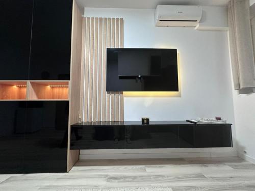 a living room with a tv on a wall at Luxury 1 bedroom apartment in Bucharest