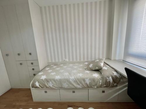 a bed in a white room with a window at Apartamentos Ciudad del Calzado in Arnedo