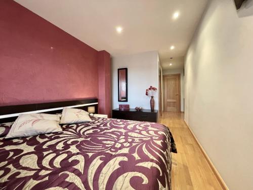 a bedroom with a large bed with a purple wall at Apartamentos Ciudad del Calzado in Arnedo