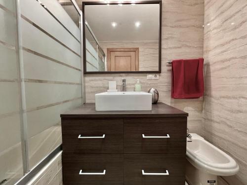 een badkamer met een wastafel en een spiegel bij Apartamentos Ciudad del Calzado in Arnedo
