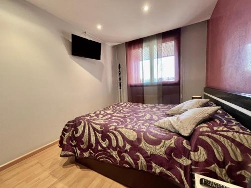 a bedroom with a bed and a television on the wall at Apartamentos Ciudad del Calzado in Arnedo