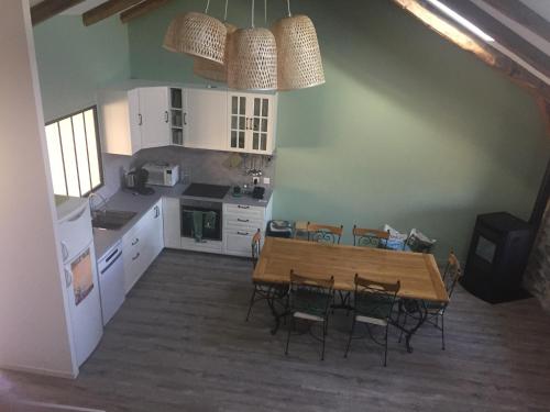 Il comprend une cuisine avec une table et des chaises en bois. dans l'établissement Gîte Jules Romains, à Saint-Julien-Chapteuil