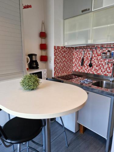 een keuken met een witte tafel in een keuken bij Studio RDC - Marina 4 - 13 allée des Pinons - 0-1 in Saint-Jean-de-Monts