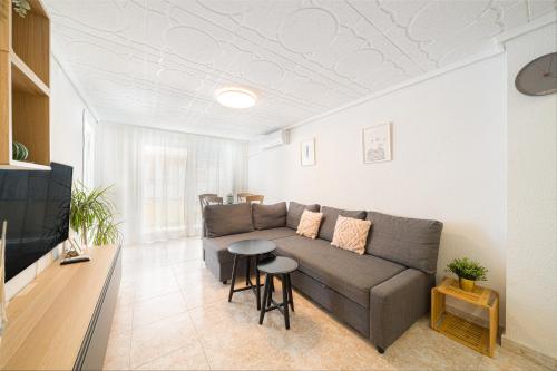 una sala de estar con un sofá y una mesa en Casita del Puerto 3, en Santa Pola
