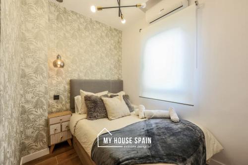 um quarto com uma cama e uma janela em MyHouseSpain - Moderno apartamento en el centro em Madri