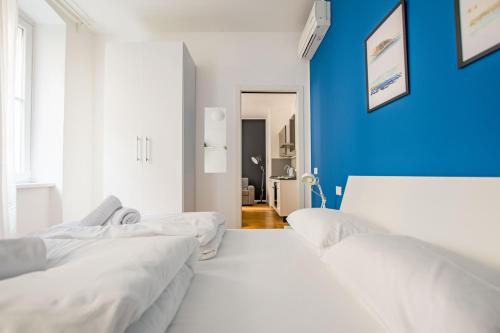 een kamer met drie bedden en een blauwe muur bij G10 in Trieste