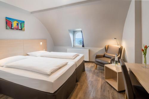 um quarto de hotel com duas camas e uma cadeira em Villa Beachside em Eckernförde