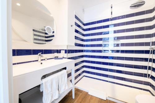a bathroom with blue and white stripes on the wall at Casa Maflogi in Sorrento