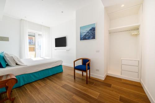 a bedroom with a bed and a blue chair at Casa Maflogi in Sorrento