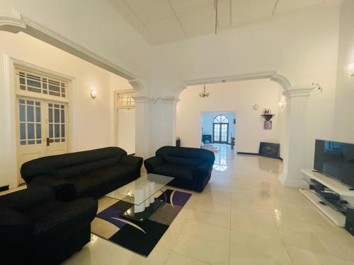 uma sala de estar com dois sofás e uma televisão em Grand Villa Negombo em Negombo
