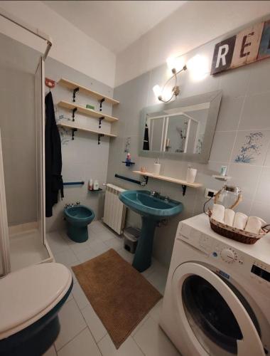 a bathroom with a toilet a sink and a washing machine at Trebiano a casa dei nonni in Arcola