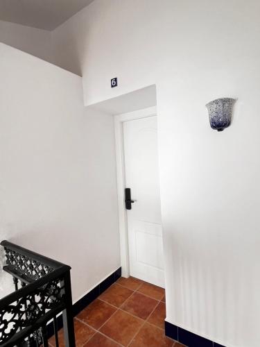 un pasillo con una pared blanca y una puerta en Shanti’s Andalusian Rooms, en Málaga