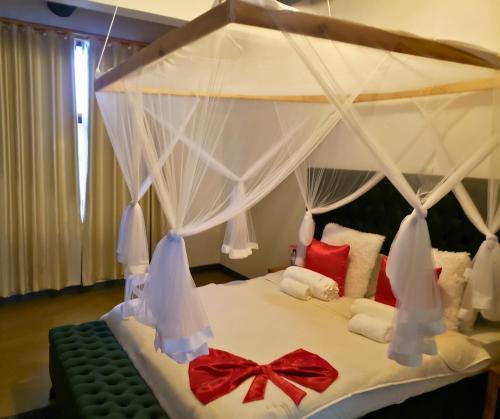 a bedroom with a white bed with a canopy at Galo do Mar in Maputo