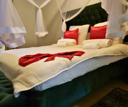 1 cama con almohadas y mantas rojas y blancas en Galo do Mar en Maputo