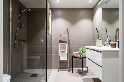 Demims Apartments Greater Oslo - Modern, Central & Stylish في Lorenskog: حمام مع دش ومرحاض ومغسلة