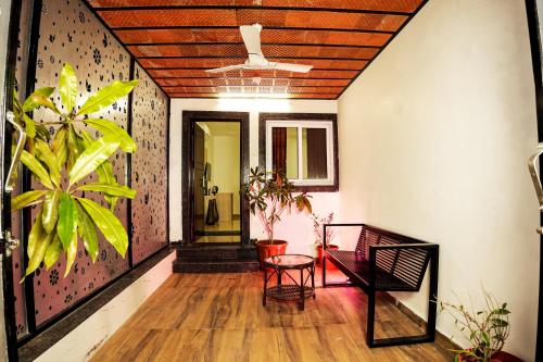 a hallway of a house with a table and chairs at GREEN MOUNT RESORTS in Malaiyāndipattanam